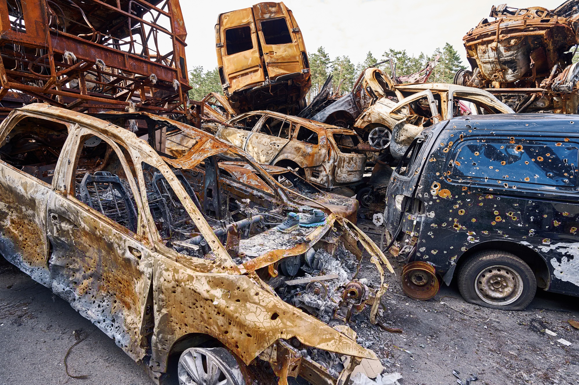Civilian vehicles with bullet holes lying on junkyard