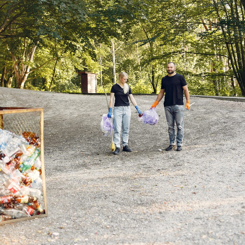 Couple collects garbage in garbage bags in park