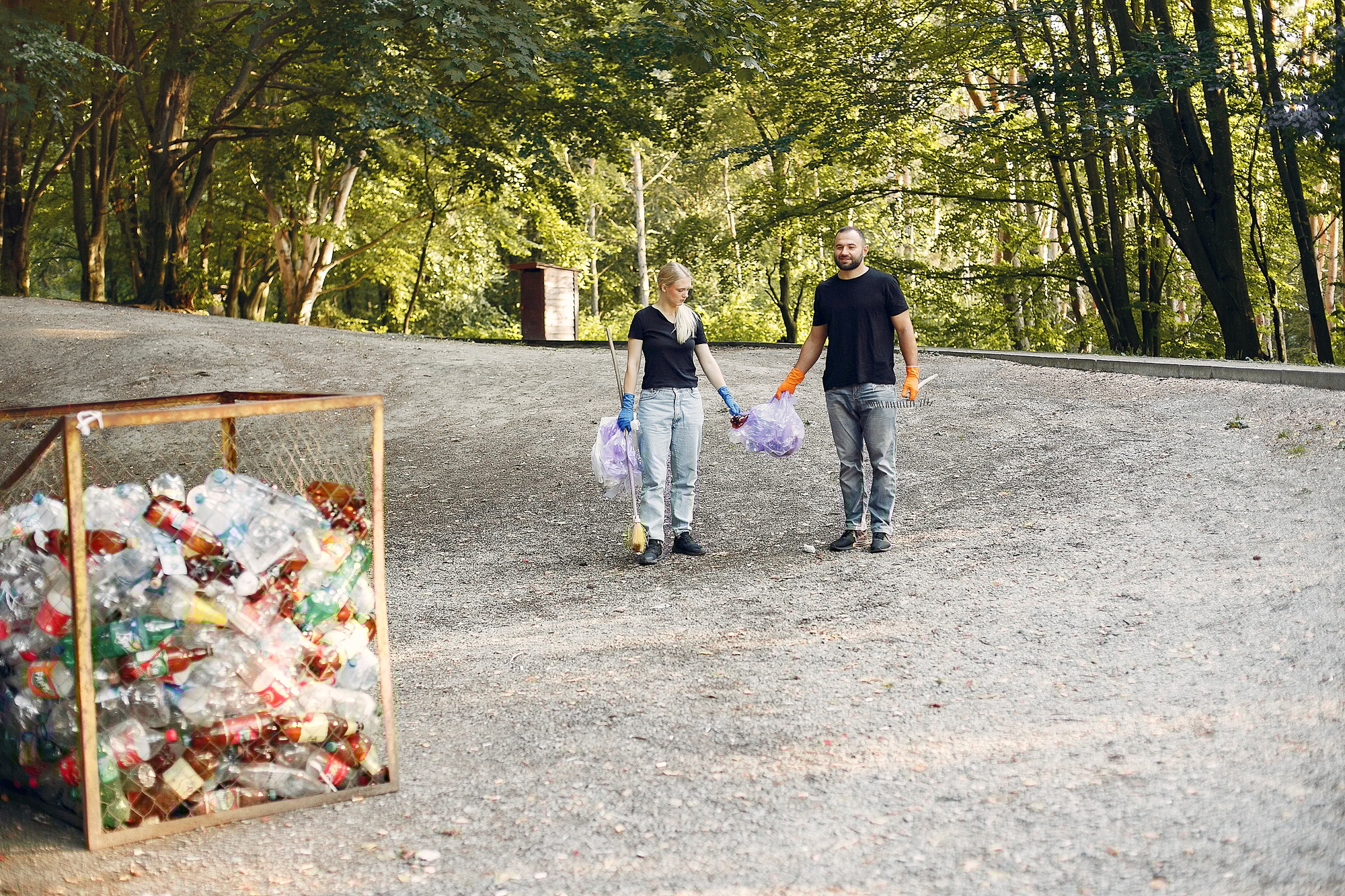 Couple collects garbage in garbage bags in park